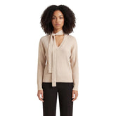 Image 1 : Femme portant le pull Liu Jo beige col V côtelé avec lien lavallière noué autour du cou, vue de face — Delvale